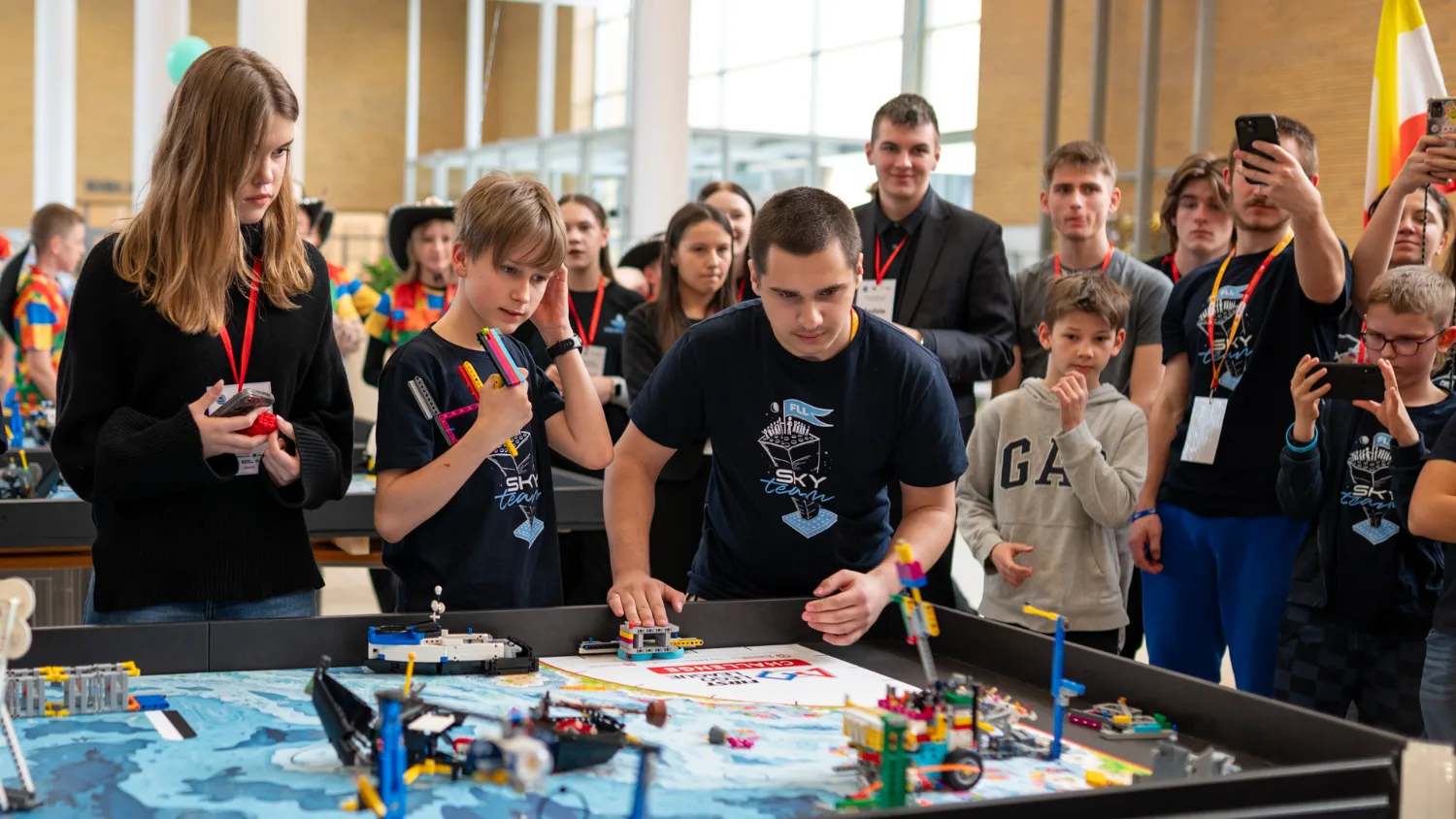 Drużyna FIRST LEGO League przy macie turniejowej, otoczona publicznością