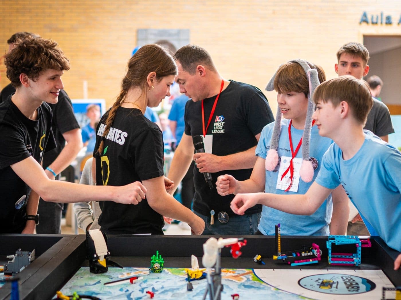 Trener prowadzi drużynę FIRST LEGO League przy macie turniejowej