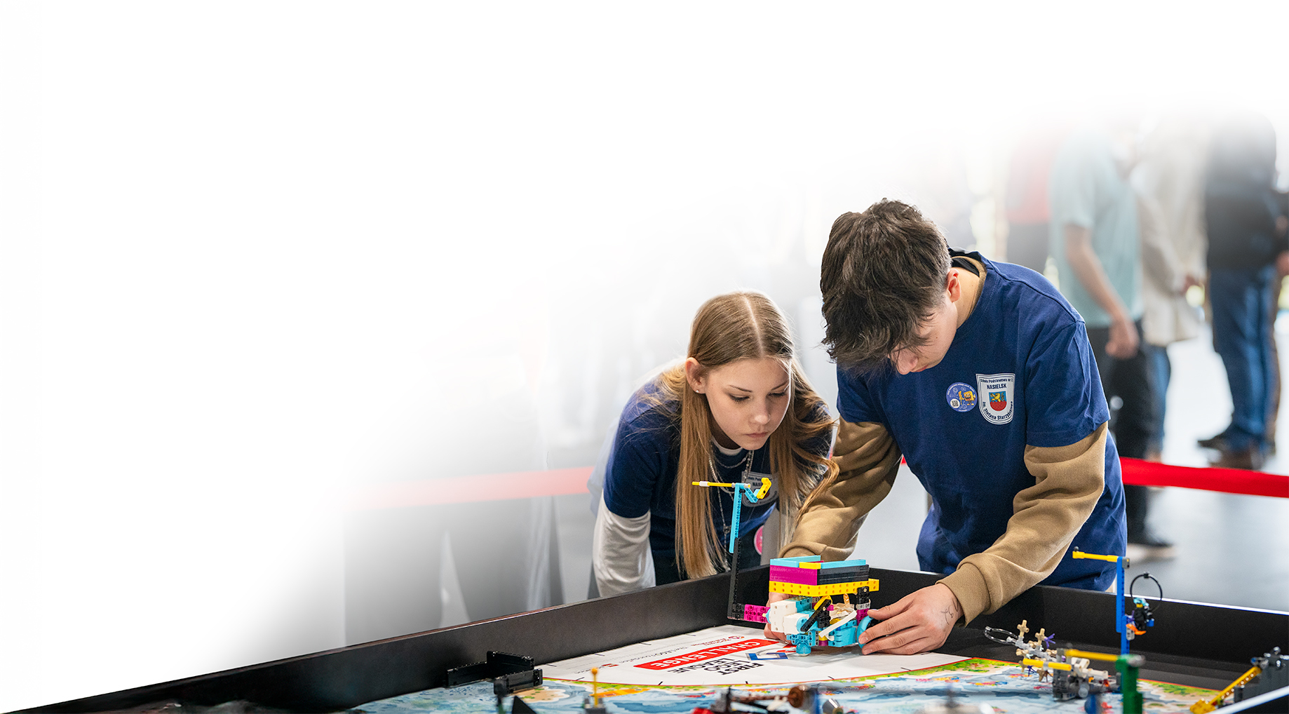 Drużyna FIRST LEGO League buduje robota przy stole turniejowym